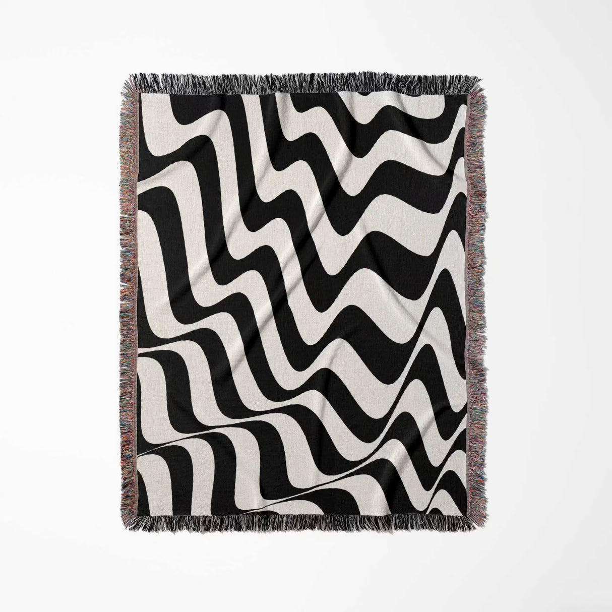 Black and white trendy abstract waves woven blanket throw tapestry vertically flat lay on a light gray background.