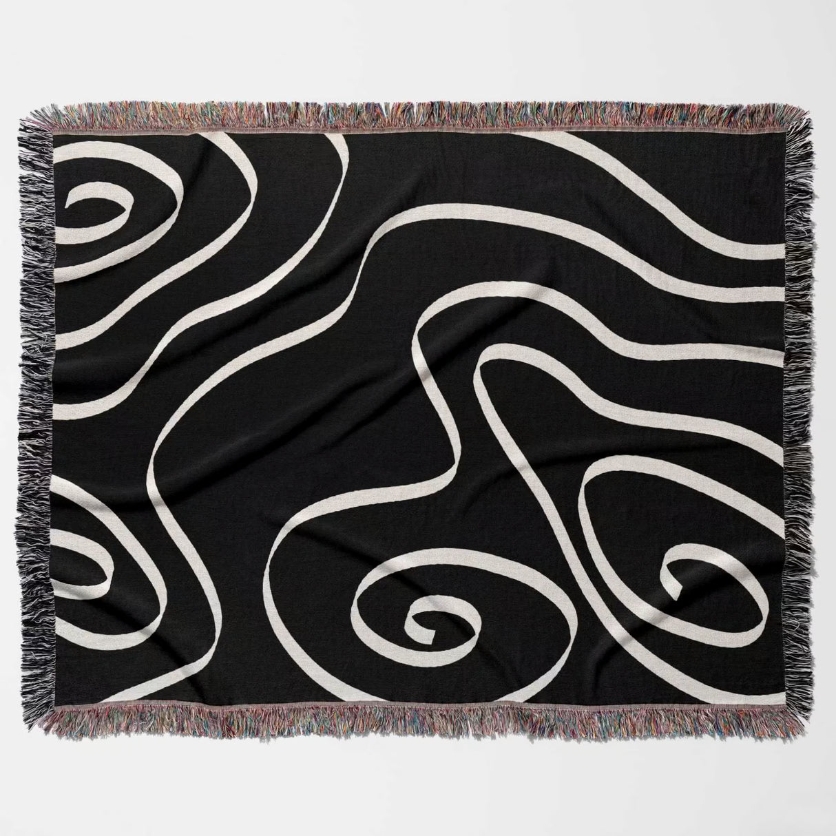 Black and white abstract art waves decorative woven blanket throw flat lay on a light gray background