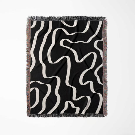 Black and white abstract waves artistic woven blanket throw full view on a white background.