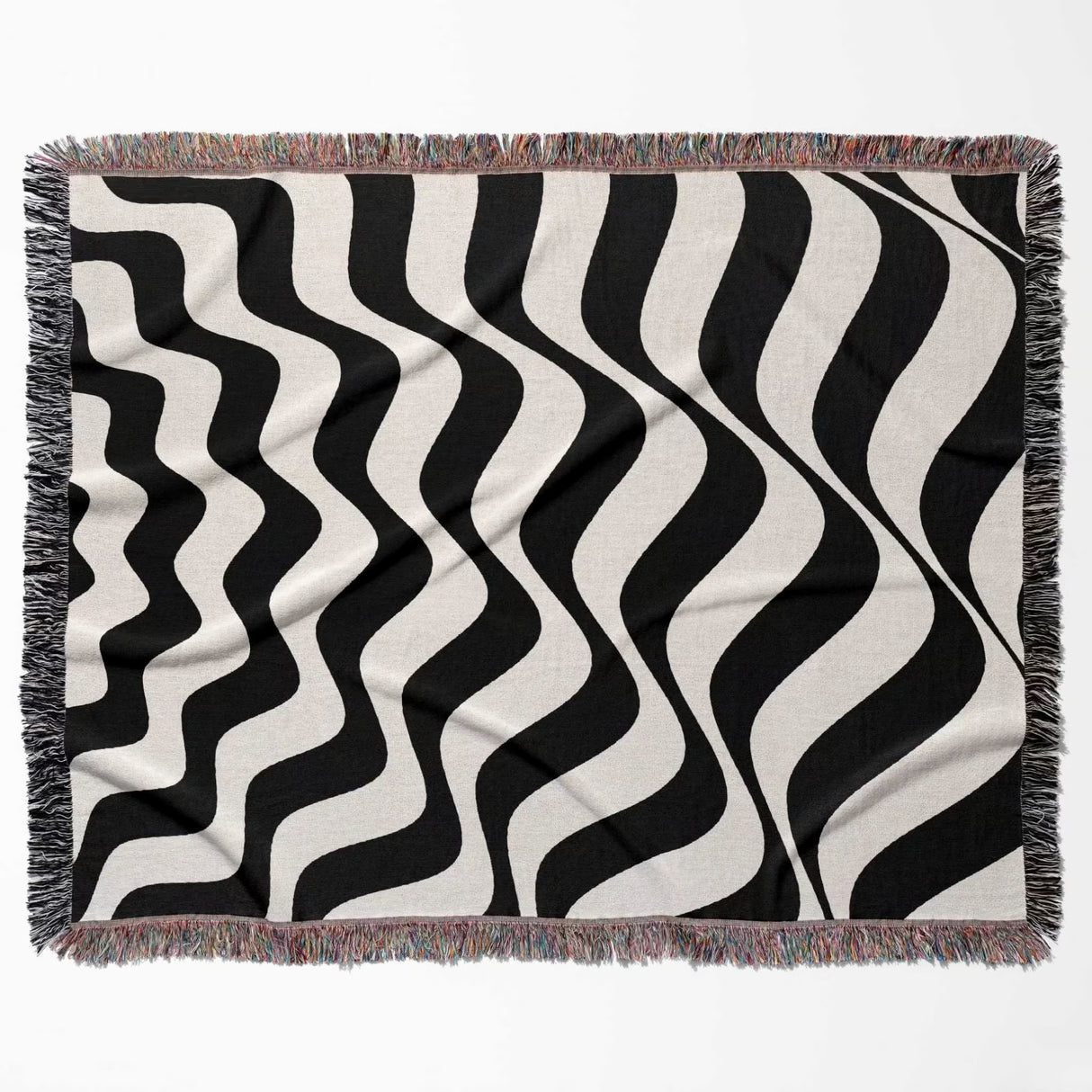 Black and white abstract wavey lines woven blanket throw tapestry flat lay on a plain background.