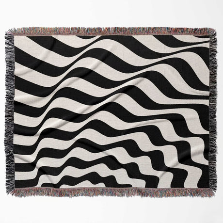 Black and white accent abstract waves woven blanket throw tapestry flat lay on a plain background.
