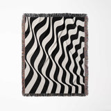 Black and white accent abstract waves woven blanket throw tapestry with fringes full view on a light gray background