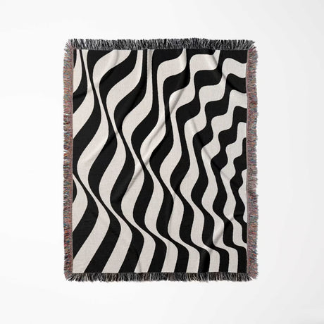 Black and white accent abstract waves woven blanket throw tapestry with fringes full view on a light gray background