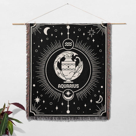 Displayed as wall art, the Aquarius Zodiac Blanket transforms into a stunning tapestry. The intricate zodiac design with the Aquarius symbol at the center is framed beautifully by the multicolor fringe. The celestial motifs add an ethereal quality to the piece, making it an eye-catching wall decoration.