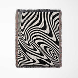 Black and white modern couch woven throw blanket with black and white abstract pattern on a light gray background