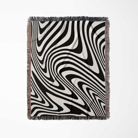 Black and white modern couch woven throw blanket with black and white abstract pattern on a light gray background