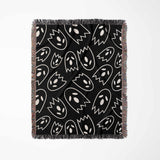 Black blanket with white ghost pattern on a white background