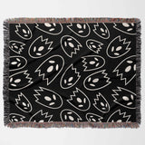 Black blanket with white abstract ghost pattern on a white background
