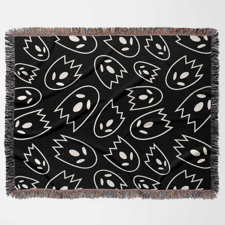 Black blanket with white abstract ghost pattern on a white background