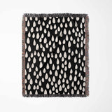 Black blanket with white teardrop pattern on a white background
