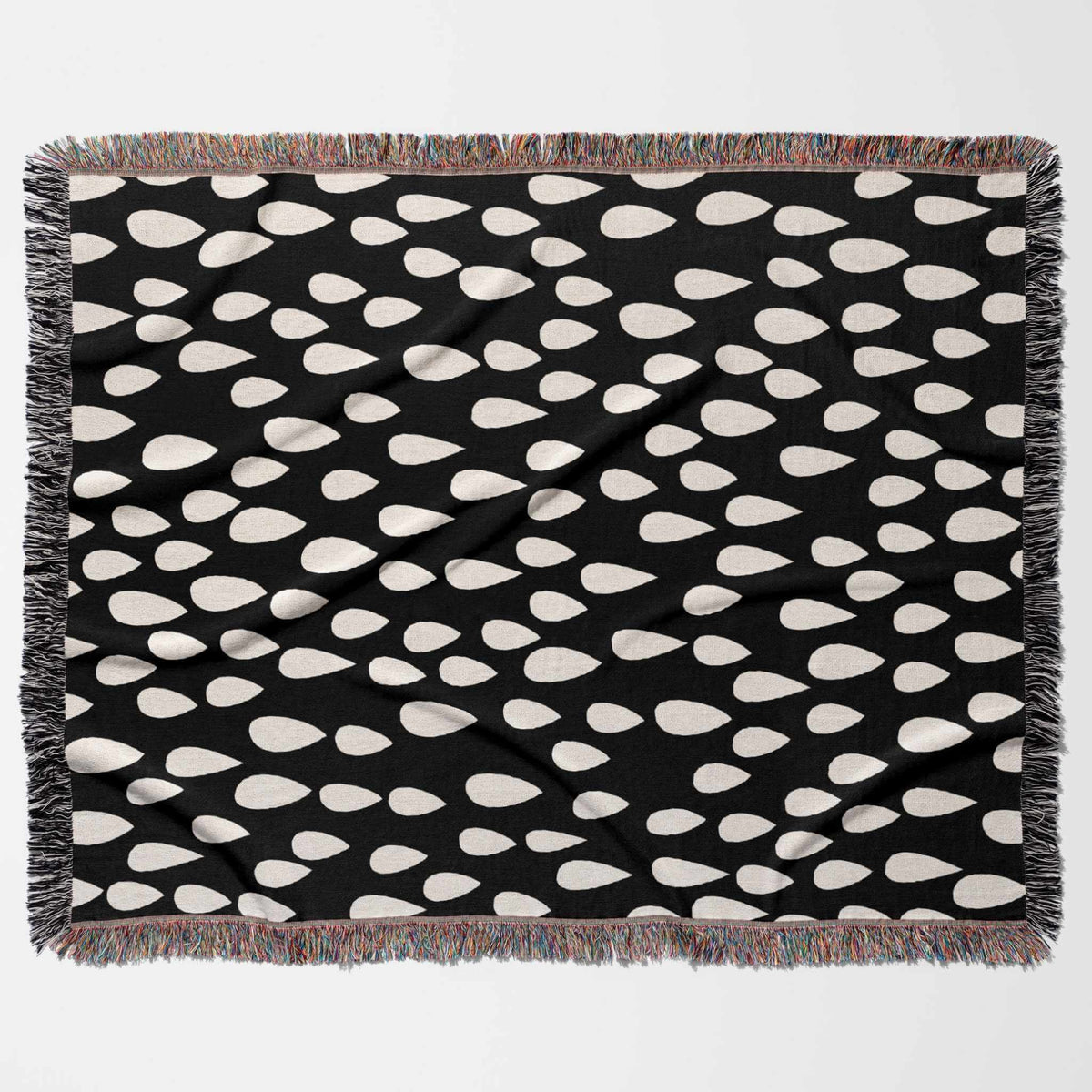 Black blanket with white teardrop pattern on a white background