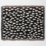 Black blanket with white teardrop pattern on a white background