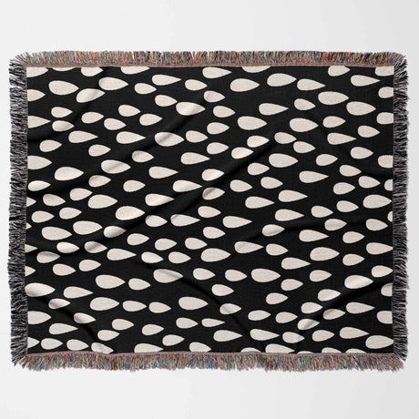 Black blanket with white teardrop pattern on a white background