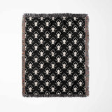 Black and white geometric spiders pattern woven throw blanket full view on a white background.