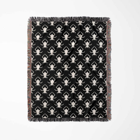 Black and white geometric spiders pattern woven throw blanket full view on a white background.