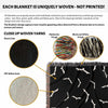 A detailed view highlighting the unique woven yarns of the black and white Halloween blanket. The image shows the black color yarn, off-white color yarn, and multicolored fringe, emphasizing the texture and craftsmanship of the woven material.