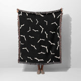 A person is holding up the Halloween blanket vertically, showcasing its bat pattern design. The size of the blanket is fully visible, emphasizing its use as a cozy throw for Halloween décor.