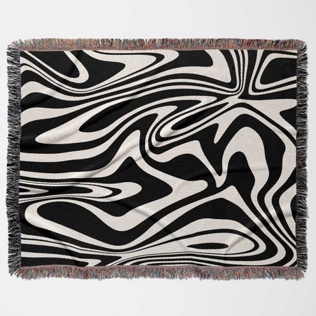 Black and white marble woven throw blanket for couch with fringed edges on a light gray background
