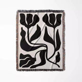Decorative black and white Matisse flower woven throw blanket  with black floral pattern on a white background