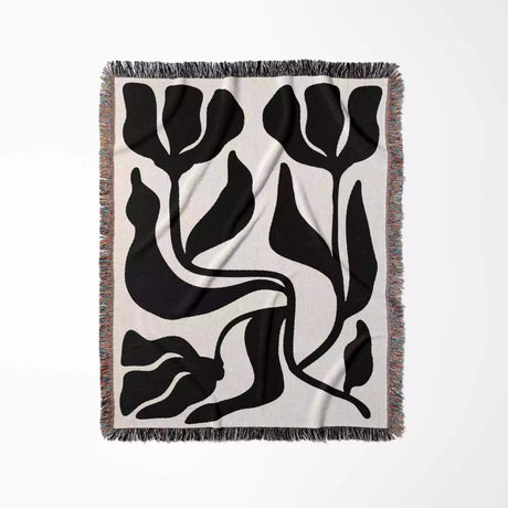 Decorative black and white Matisse flower woven throw blanket  with black floral pattern on a white background