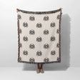 Person holding a blanket with black spider patterns on a white background