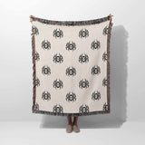 Person holding a blanket with black spider patterns on a white background