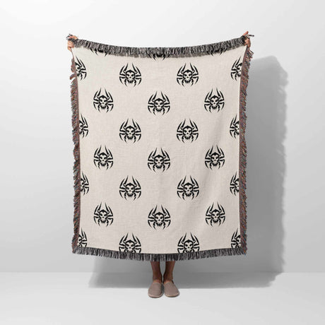 Person holding a blanket with black spider patterns on a white background