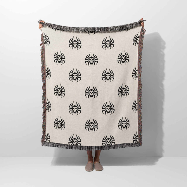 Person holding a blanket with black spider patterns on a white background