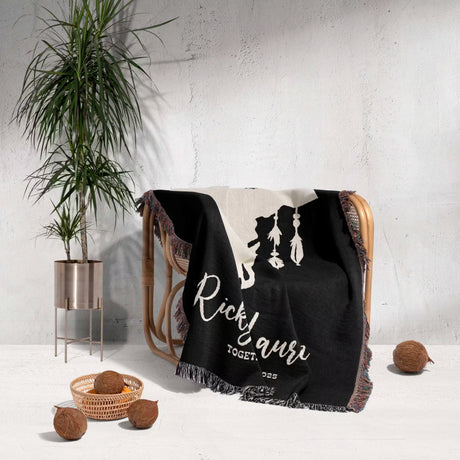 Bull skull boho wedding 2nd anniversary gift woven throw blanket with white text draped over a chair next to a plant and coconuts on a light gray background