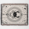 This image shows a flat lay of a Cancer Zodiac Blanket. The woven tapestry blanket features a black-and-white design with a bold crab emblem and celestial motifs. Perfect for adding a personalized touch to any room, it combines comfort with astrological elegance.