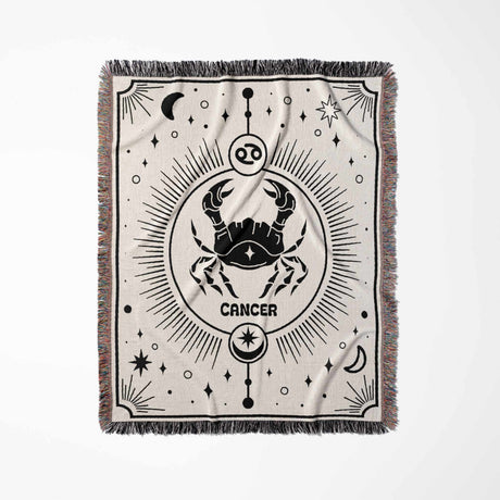 This image displays a vertical flat lay of a Cancer Zodiac Blanket. The intricate black-and-white design features a crab surrounded by celestial elements, making it ideal for home decor and astrology enthusiasts.