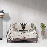 The Capricorn Zodiac Blanket elegantly displayed on a couch, illustrating its size and design in a living room setting. Ideal for birthdays, this woven throw blanket combines comfort and zodiac-themed decor, making it a perfect gift for both women and men.