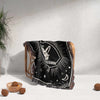 A cozy Capricorn Zodiac Blanket draped over a wicker chair. The blanket's detailed design is partially visible, showcasing the Capricorn symbol and celestial motifs against a black background. The multicolored fringe adds a decorative touch to the chair.