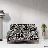 Sofa with a black and white classical checker board pattern woven blanket throw against a white wall.