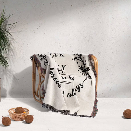 Cotton wedding anniversary gift for him woven throw blanket with text and patterns draped over a chair against a light background