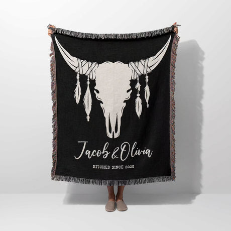Cow skull wedding 2nd anniversary gift woven throw blanket with a white bull skull design and text, held by a person on a white background