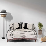 Cowboy boots wedding cotton anniversary gift woven throw blanket with cowboy boot design draped over a couch in a room with a lamp and plant.