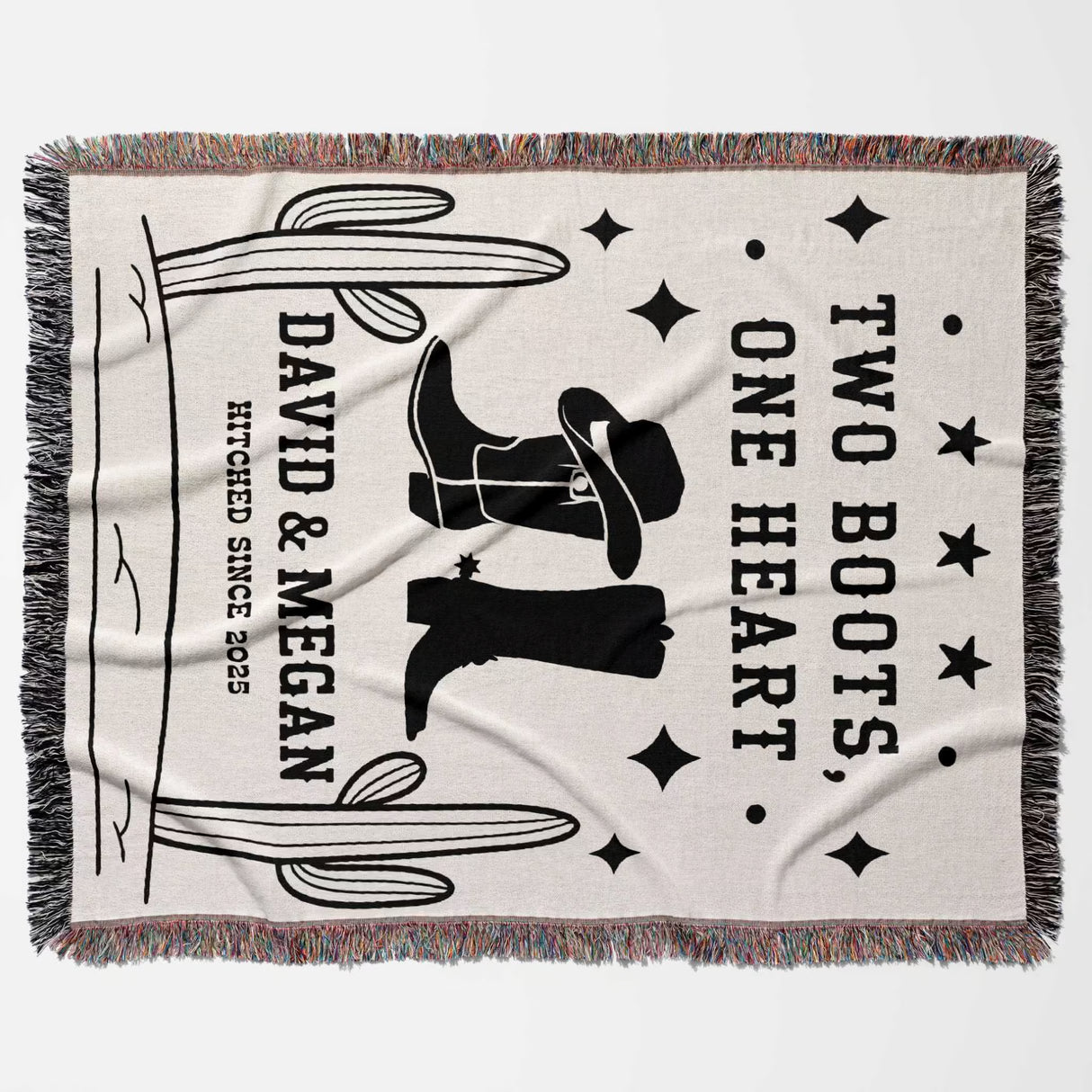 Cowboy boots wedding cotton anniversary gift woven throw blanket flat lay with cowboy boot and hat design, text 'Two Boots, One Heart', and fringes on a white background