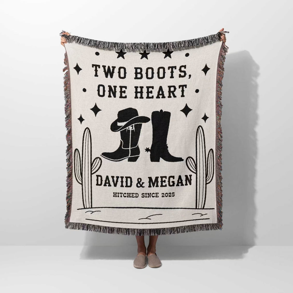Cowboy boots wedding cotton anniversary gift woven throw blanket held by a person with cowboy boots and text on a white background