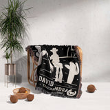 Cowboy and cowgirl 2nd anniversary gift woven throw blanket with white graphics and text draped over a chair, with a plant and decorative items in the background.