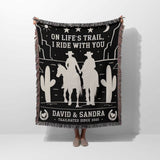 Cowboy and cowgirl 2nd anniversary gift woven throw blanket held by a person with cowboy design and text on a white background
