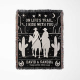 Cowboy and cowgirl 2nd anniversary gift woven throw blanket flat lay with western desert scene design, text, and silhouettes of a couple on a horse.