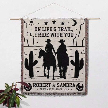 Cowboy and cowgirl cotton anniversary gift woven throw blanket as wall art tapestry with cowboy design and text on a white wall