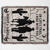 Cowboy and cowgirl cotton anniversary gift woven throw blanket flat lay with cowboy design, text, and fringes on a white background