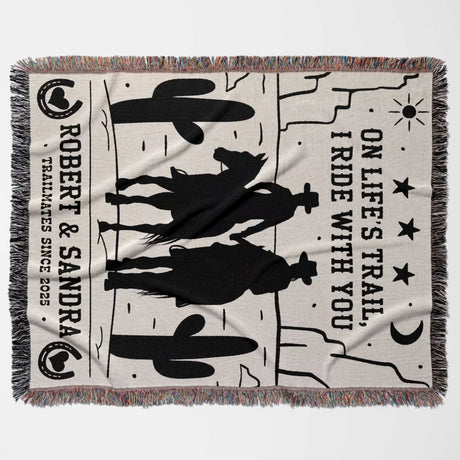 Cowboy and cowgirl cotton anniversary gift woven throw blanket flat lay with cowboy design, text, and fringes on a white background