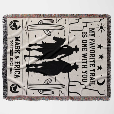 Cowboy and cowgirl couple cotton anniversary gift woven throw blanket flat lay with cowboy design, text, and fringes on a white background