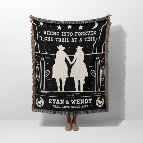 Cowboy and cowgirl western 2nd anniversary gift woven throw blanket with desert design and text, held by a person on a white background