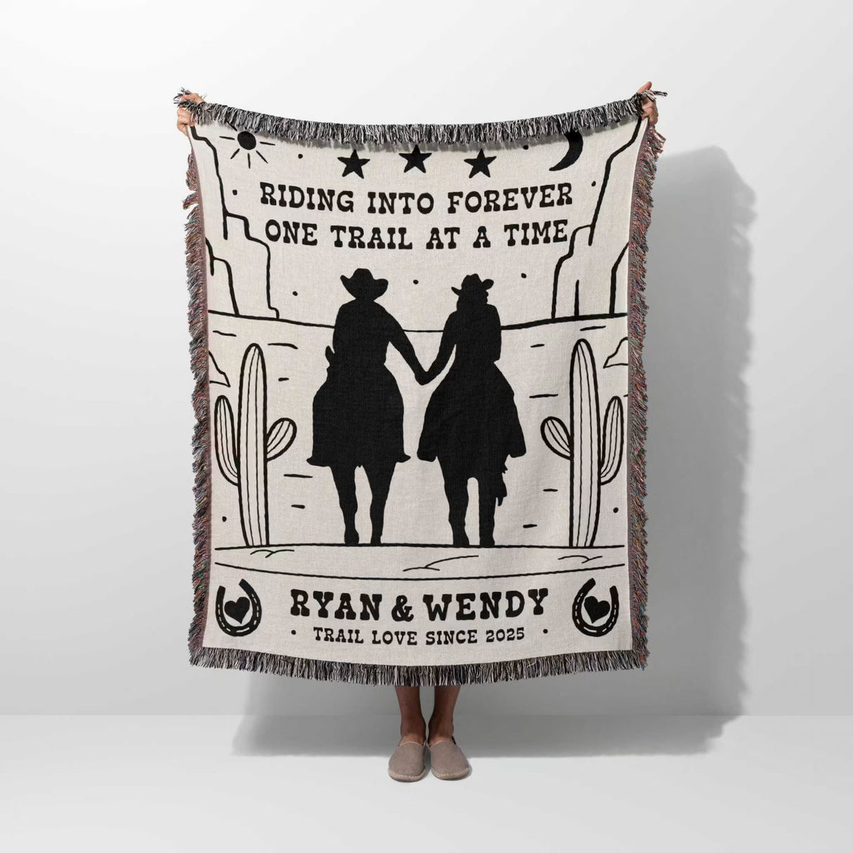 Cowboy and cowgirl western cotton anniversary gift woven throw blanket with cowboy design and text, held by a person on a white background