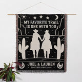 Cowboy and cowgirl on two horses 2nd anniversary gift woven throw blanket as a wall hanging with desert scene design, couple holding hands, and text 'My favorite trail is one with you' by Joel & Lauren.