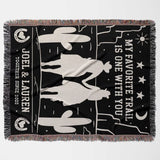 Cowboy and cowgirl on two horses 2nd anniversary gift woven throw blanket flat lay with horse design and text on a black background